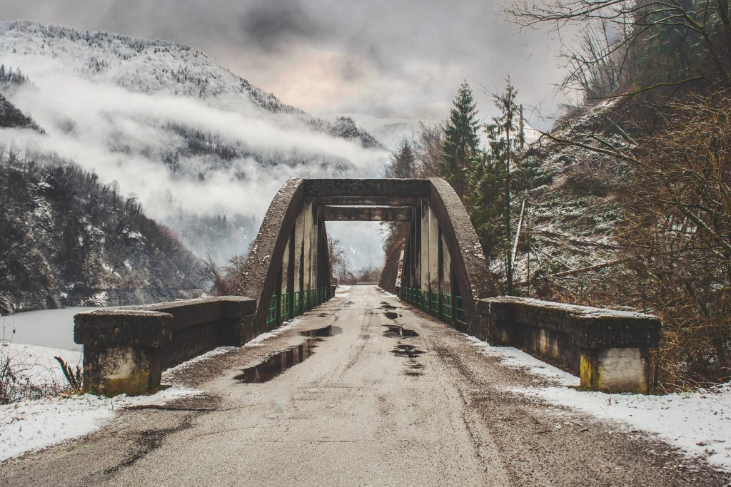 bridge and mountains with fog and snow
